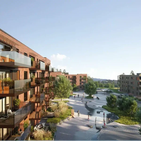 Moderne boligblokker med trefasader vender ut mot en anlagt gårdsplass med trær, gangstier og mennesker som nyter uterommet på en solrik dag.
