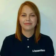 Joanna-Drammen-e1599464718712-300x300 En kvinne med rett, skulderlangt, blondt hår og mørk skjorte med logoen "Lássentere" står mot en lys bakgrunn.