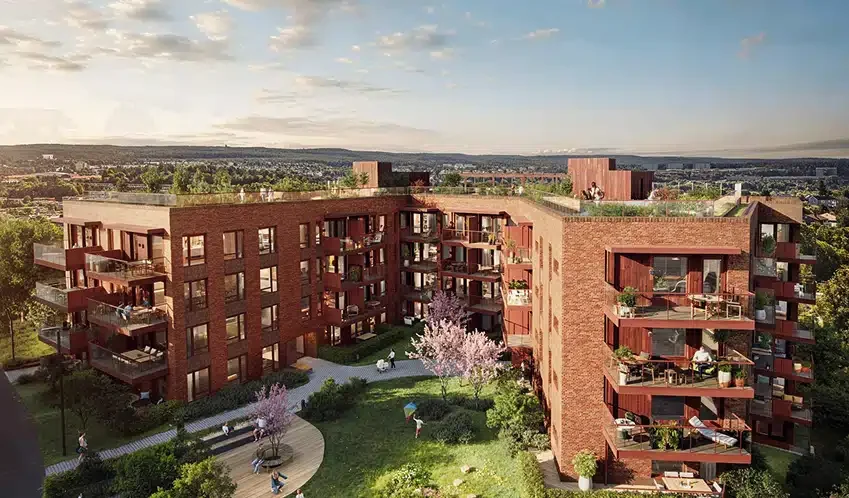 Neptune-Properties-Building_-Skoyen-Prinsessealleen-2 Moderne fleretasjes bygård i rød teglstein med balkonger, takhager, hageanlegg, og folk som går og sitter ute på en solrik dag.