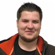 Otto-Toien-300x300 En mann med kort, mørkt hår og trimmet skjegg smiler. Han er iført svart skjorte og brun jakke med oransje fôr, mot en ensfarget hvit bakgrunn.