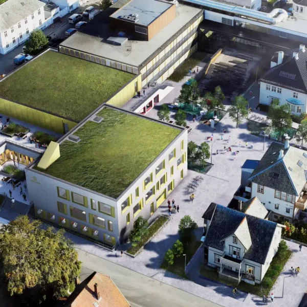 Luftfoto av et bykvartal med moderne bygninger med grønne tak side om side med eldre hus og et sentralt torg med fotgjengere.