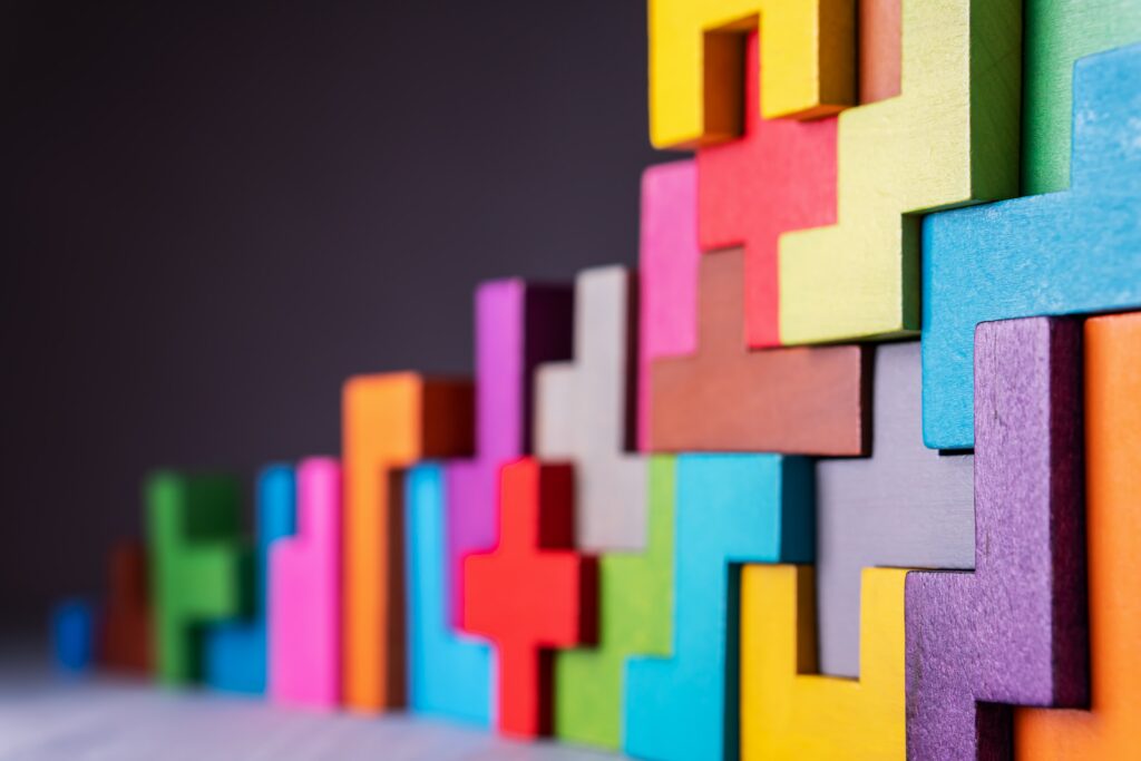 Fargerike Tetris-lignende treklosser, stablet vertikalt i et sammenlåsende mønster, ligner et adgangskontrollsystem mot en mørk bakgrunn.