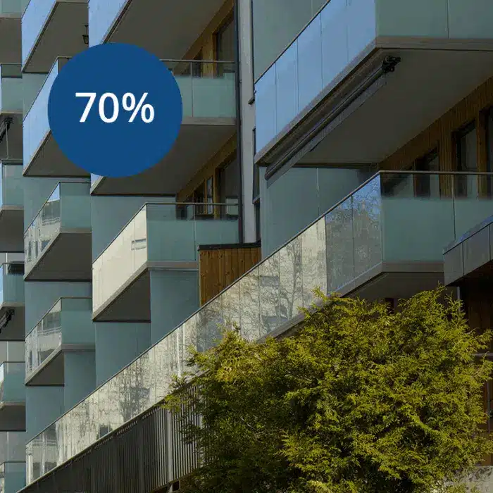 lassystem-700x700 Moderne boligblokk med glassbalkonger og et tre foran; en blå sirkel viser "70 %".